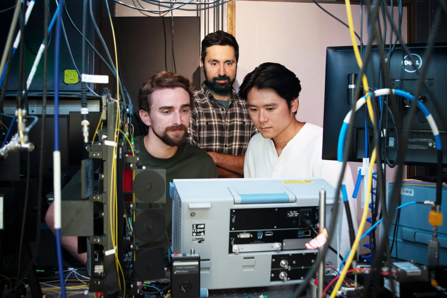 Study co-authors Erik Szakiel (left), Professor Amir Safavi-Naeini, and Takuma Makihara look at radio frequency instrumentation.